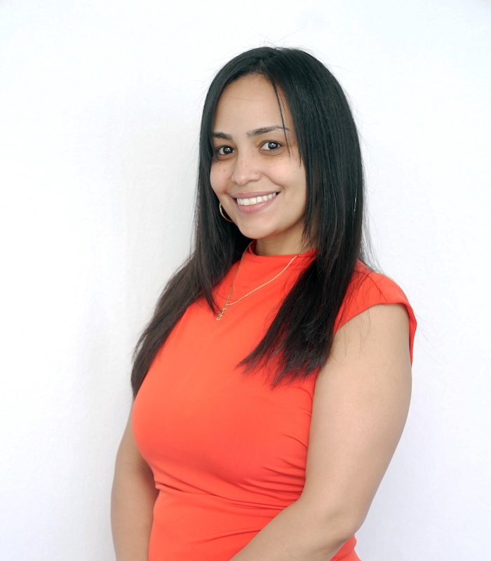 Meet Our Team - Professional and Welcoming Group at a Conference Table Faces the Camera, Team Leader Sitting on the Table with Arms Folded